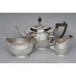 A SILVER COMPOSITE THREE PIECE TEA SERVICE, maker Huttons, London 1901, 1904 (teapot) and 1923 (