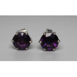 A PAIR OF AMETHYST STUD EARRINGS, the circular facet cut stones claw set to white posts, butterflies