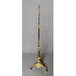 A BRASS STANDARD LAMP, early 20th century, the turned tapering stem with gadrooned collars, the