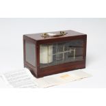 A BAROGRAPH by Negretti & Zambra, the drum inscribed "Gluck Co Ltd", the glazed mahogany case with