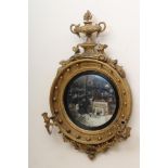 A REGENCY CONVEX MIRROR, the cavetto frame with applied orbs, foliate inner border and reeded