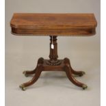 A REGENCY MAHOGANY FOLDING TEA TABLE of rounded oblong form, reeded edged swivel top over plain