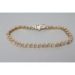 A DIAMOND TENNIS BRACELET, the forty round brilliant cut stones claw set to a plain unmarked