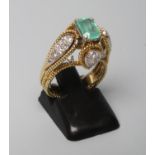 AN INDIAN STYLE EMERALD AND DIAMOND COCKTAIL RING, the oblong cut emerald claw set to high rope