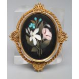 A VICTORIAN PIETRA DURA BROOCH, the oval panel depicting a loose posy of flowers in a plain unmarked