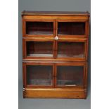 A MAHOGANY GLAZED BOOKCASE, early 20th century, of shallow oblong form with raised shaped ends and