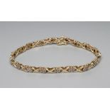 A DIAMOND BRACELET, the eighteen flower clusters each set with seven small stones and with scroll