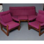 A GUY ROGERS AFROMOSIA WOOD VIRGINIA THREE PIECE LOUNGE SUITE button upholstered in a purple