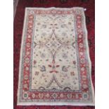 A PERSIAN RUG, modern, the ivory field with flowers and foliate in pale blue and red with a red
