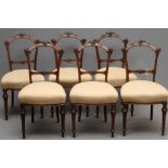 A SET OF SIX VICTORIAN WALNUT DINING CHAIRS upholstered in a cream and rust weave, the tapering open