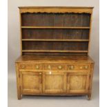 A GEORGIAN OAK DRESSER, c.1800, the boarded delft rack with moulded cornice over waved frieze and