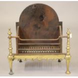 A BAROQUE STYLE CAST IRON AND BRASS FIRE BASKET, c.1900, the plain arched backplate with dished