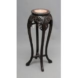 A CHINESE PADOUK WOOD JARDINIERE STAND, c.1900, the circular top with leaf carved edge and inset