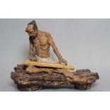 A CHINESE SHIWAN STONEWARE FIGURE, the seated ascetic with long pony tail, moustache and beard,