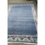 A CHINESE WASHED AND FRINGED CARPET, late 20th century, in powder blue with a wide border of