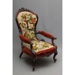 A VICTORIAN ROSEWOOD SHOW FRAME ARMCHAIR of spoonback form carved with trailing flowers and