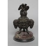 A FRENCH BRONZE INKWELL, 19th century, adorned with three ram's heads on hoof feet, spaced by