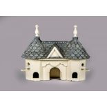 AN EDWARDIAN(?) PAINTED WOOD BIRD HOUSE modelled as a cottage orne, the scalloped lead roof with