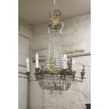 A GILT METAL AND GLASS BEAD CHANDELIER, c,1900, of pear form with Empire style surmounts, the