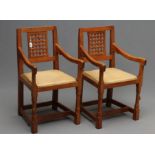 A PAIR OF PETER HEAP ADZED OAK ELBOW CHAIRS, the straight top rail on pierced latticed panel back,