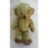 A Merrythought cheeky bear, with amber eyes, sewn nose, bells within ears, jointed body and felt