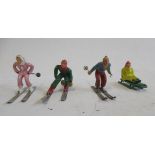 Four 60mm figures, unknown manufacturers, three are downhill skiers and a seated tobogganist, G
