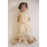 An Armand Marseille bisque socket head doll, with blue glass eyes, open mouth, teeth, brown wig,