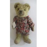 An early English teddy, with clear glass eyes, sewn nose, light orange plush, red sewn finger and