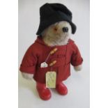 A Paddington bear, with red coat, red wellies and label