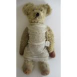A pre-war teddy, with clear glass eyes, sewn nose, light orange plush, straw filled jointed body,
