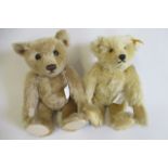 Two Steiff teddy bears, one with light orange plush, ear button and label, the other with darker