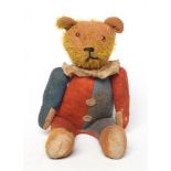 A rare pre-war jester teddy, with orange glass eyes, sewn nose, orange plush, red and blue felt