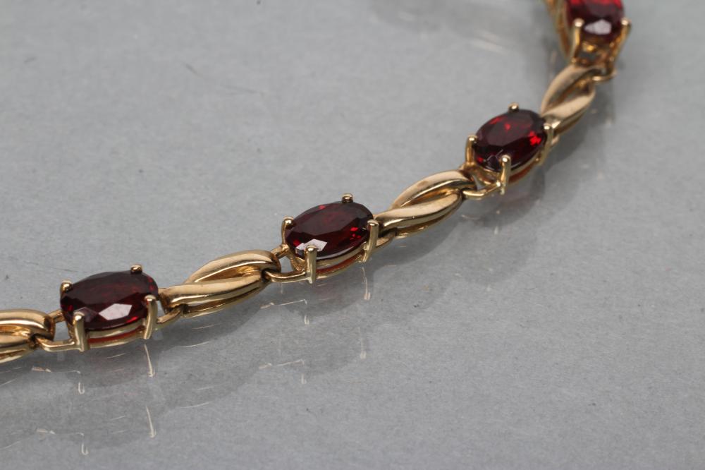 A GARNET BRACELET, the twelve oval facet cut stones claw set to a plain chain, stamped 375 (Est. - Image 2 of 2