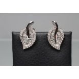 A PAIR OF DIAMOND FRENCH CLIP EARRINGS, the leaf shaped panels set with baguette and brilliant cut