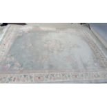 A CHINESE WASHED AND FRINGED CARPET, the pale green field with central circular floral gul in rose