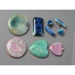 FOUR RUSKIN POTTERY BROOCH PANELS, glazed in shades of green and blue, and pink and green,