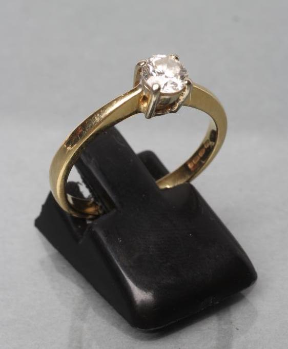 A SOLITAIRE DIAMOND RING, the brilliant cut stone of approximately 0.6cts claw set to a plain 18ct