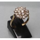 A DIAMOND CLUSTER RING, the nineteen brilliant cut stones claw set to a plain 18ct gold shank,