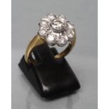 A DIAMOND CLUSTER RING, the central round brilliant of approximately 0.12cts to a frilled border and