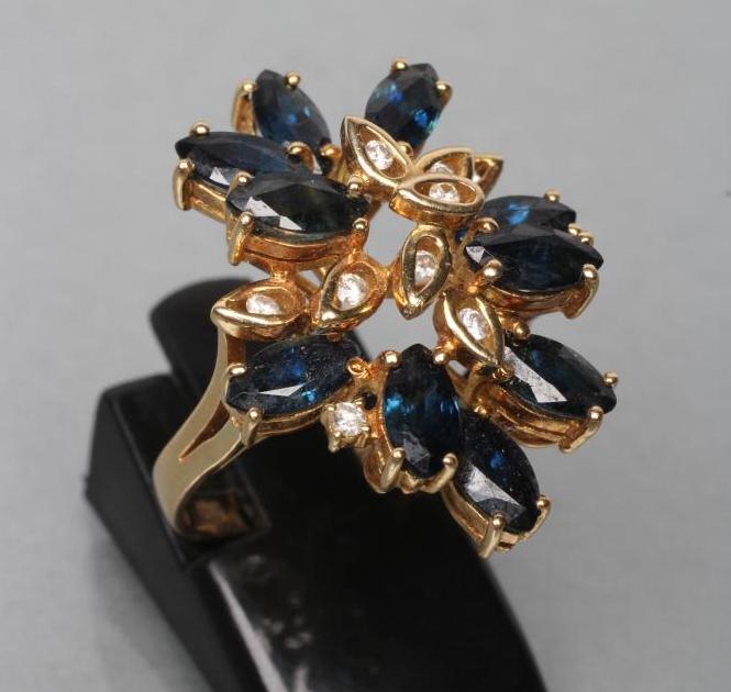 A SAPPHIRE AND DIAMOND COCKTAIL RING, set with ten marquise cut sapphires and nine single channel