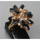 A SAPPHIRE AND DIAMOND COCKTAIL RING, set with ten marquise cut sapphires and nine single channel