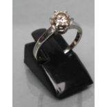 A SOLITAIRE DIAMOND RING, the round brilliant of approximately 0.4cts claw set to a plain white