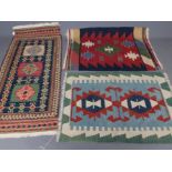A FLAT WEAVE KILIM RUG, the navy blue field with three guls in shades of blue, ivory, red and green,