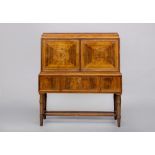 A ROSEWOOD DRINKS CABINET, first half of the 20th century, of oblong form with stringing, the