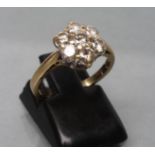 A DIAMOND CLUSTER RING, the seven old cut stones point set to a plain shank stamped 18k, size I 1/