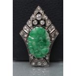 AN ART DECO JADE AND DIAMOND BROOCH, the oval green jade panel carved with fruits and claw set to