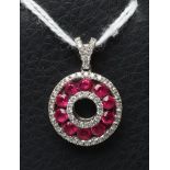 A RUBY AND DIAMOND "DOUGHNUT" PENDANT, the channel set round facet cut rubies to borders of small