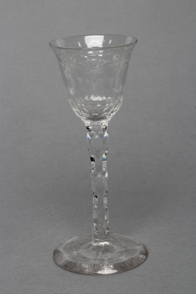 A WINE GLASS, late 18th century, the round funnel bowl with pendant husk and foliate engraved rim,