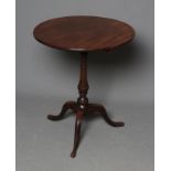 A GEORGIAN MAHOGANY TRIPOD TABLE, late 18th century, the circular tip-up top on ring turned vase