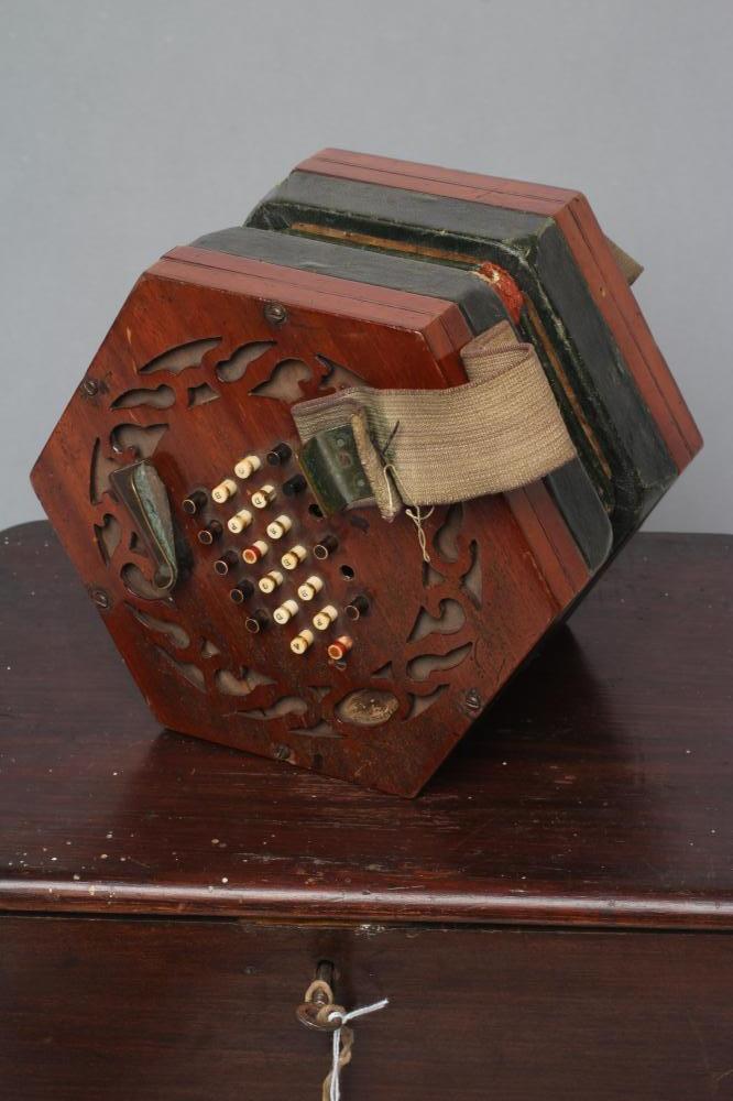 A VICTORIAN CONCERTINA by John Alfred Mills, the hexagonal ends blind fret pierced with a